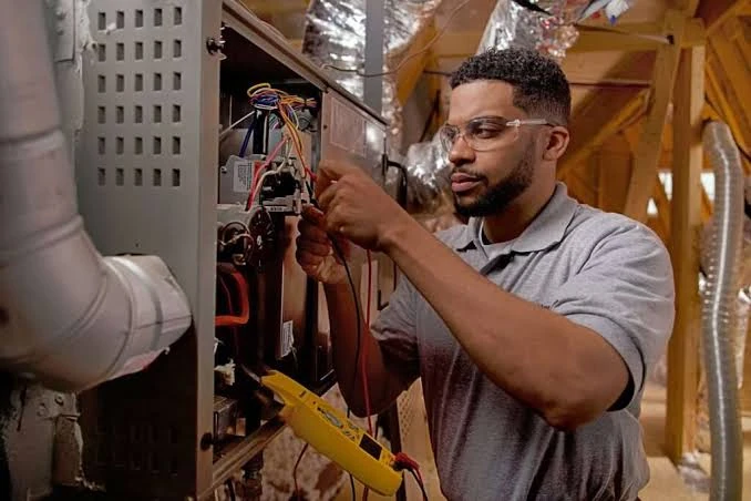 Technician inspecting wiring inside a home heating system
