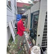 HVAC technician working on an outdoor system in a service passage